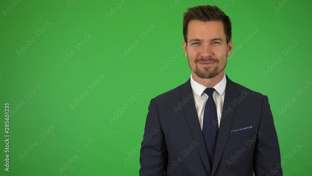 A young handsome businessman smiles at the camera - green screen studio A young handsome businessman smiles at the camera - green screen studio