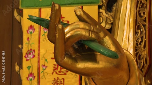 Extreme close-up low-angle still shot of Golden Buddha's Karana Mudra Hand Gesture for expelling or warding off the evil, Kek Lok Si Temple, Penang, Malaysia photo