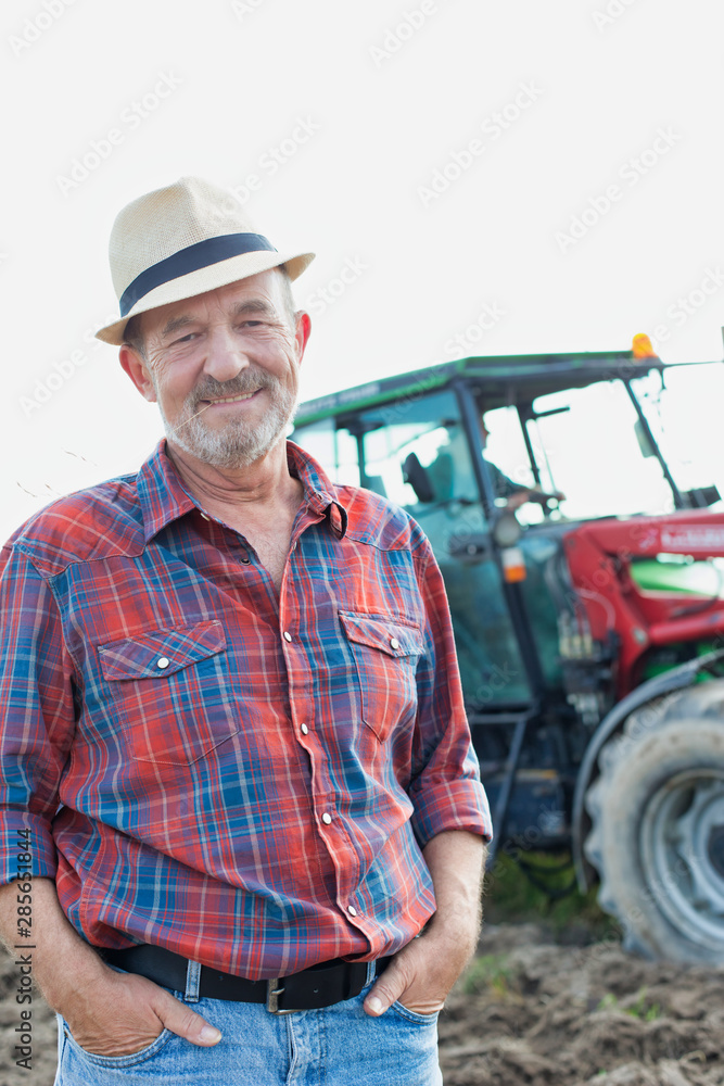 Portrait of smiling senior farmer standing with hands in pocket at farm Portrait of smiling senior farmer standing with hands in pocket at farm