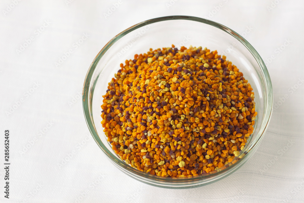 Bee pollen granules in a glass bowl on white background. Superfood. Copy space. Bee pollen granules in a glass bowl on white background. Superfood. Copy space.