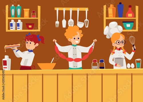Children boys and girls cooking in the kitchen in aprons and cook caps at the table.