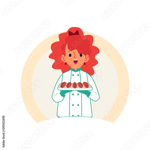 Little Caucasian redheaded girl carries or keeps cakes and pastries on a tray.