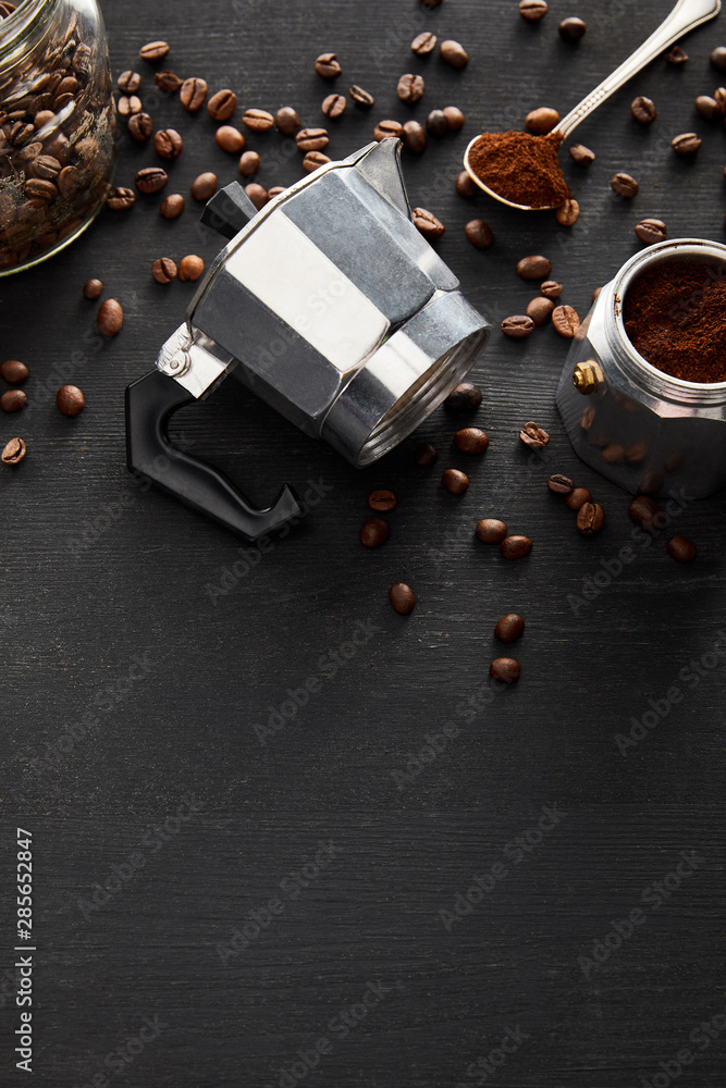 Separated parts of geyser coffee maker near glass jar and spoon on dark wooden surface with coffee beans Separated parts of geyser coffee maker near glass jar and spoon on dark wooden surface with coffee beans