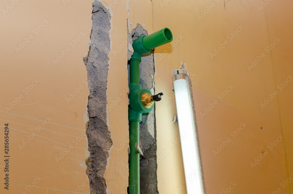 New plastic water pipes installed in a chased bathroom wall and a neon