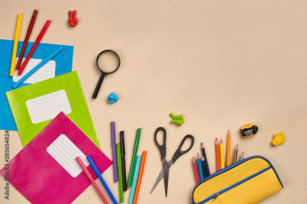 Fototapeta premium Flat lay photo of workspace desk with school accessories or office supplies on pink background.