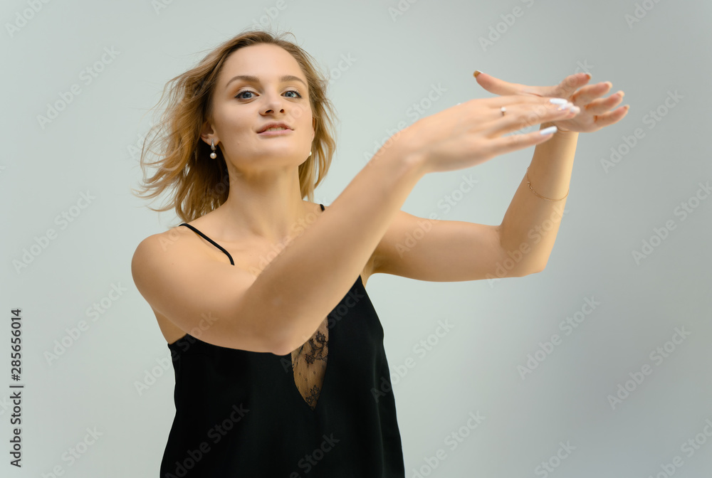 Photo studio portrait of a cute blonde young woman girl in a black blouse on a white background. He stands right in front of the camera, explains with emotion. Photo studio portrait of a cute blonde young woman girl in a black blouse on a white background. He stands right in front of the camera, explains with emotion.