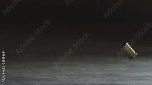 Shooting.The cartridge from the gun falls to the ground.Reload the gun. Slow motion