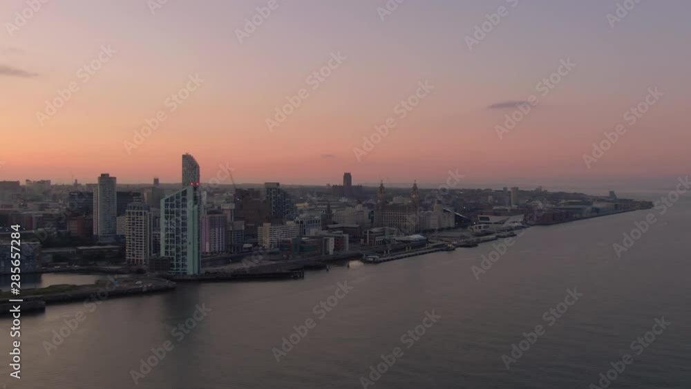 liverpool city skyline aerial view at dawn flying backwards over mersey river uk england liverpool city skyline aerial view at dawn flying backwards over mersey river uk england