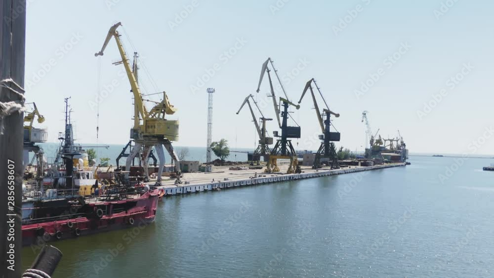 Sea port cranes. Commercial port steel in summer day. Urban landscape. Cargo ship at port. Construction of the ship in shipyard Sea port cranes. Commercial port steel in summer day. Urban landscape. Cargo ship at port. Construction of the ship in shipyard