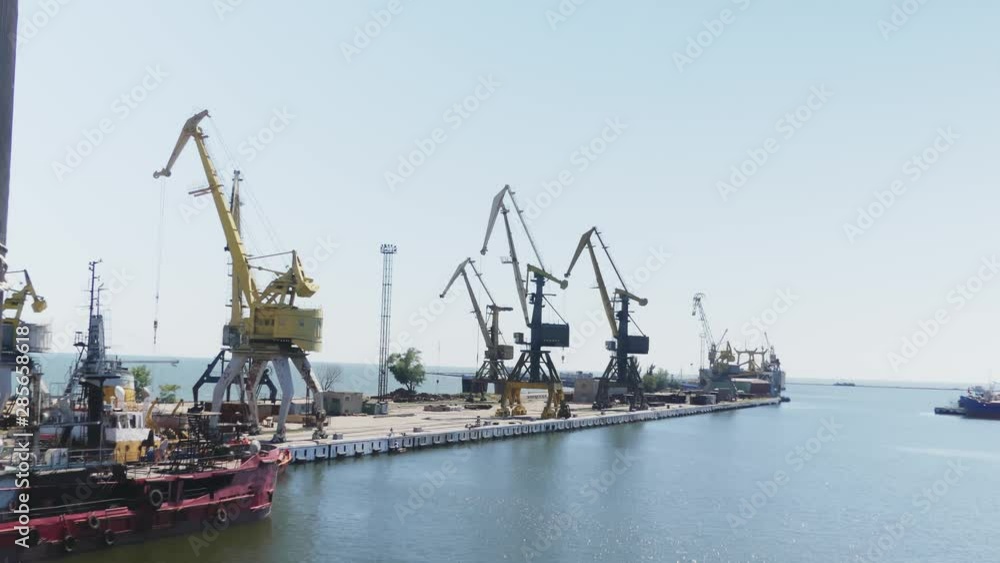 Sea port cranes. Commercial port steel in summer day. Urban landscape. Cargo ship at port. Construction of the ship in shipyard Sea port cranes. Commercial port steel in summer day. Urban landscape. Cargo ship at port. Construction of the ship in shipyard