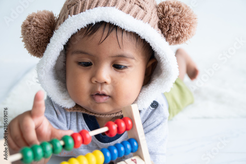 cute little asin baby boy playing with wooden toy photo