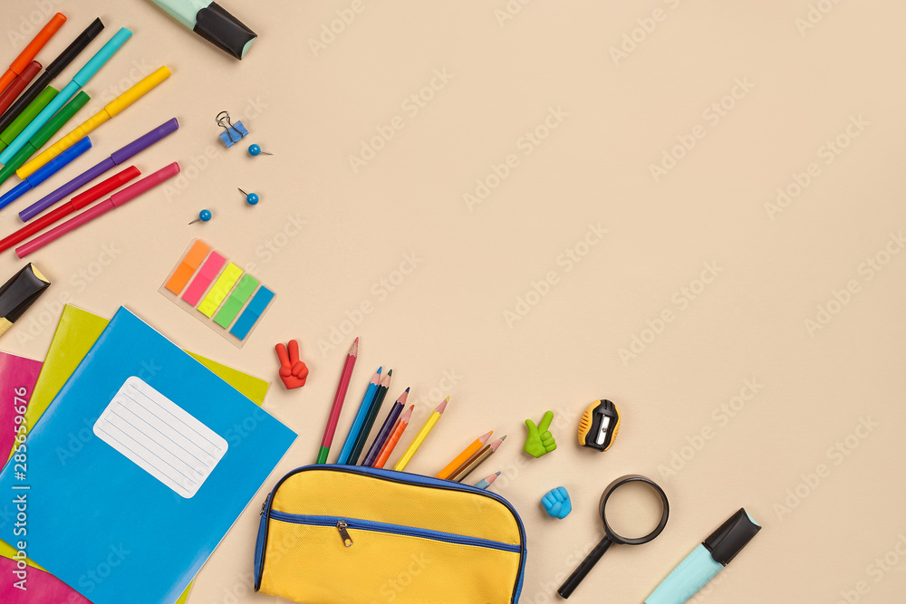 Fototapeta premium Flat lay photo of workspace desk with school accessories or office supplies on pink background.