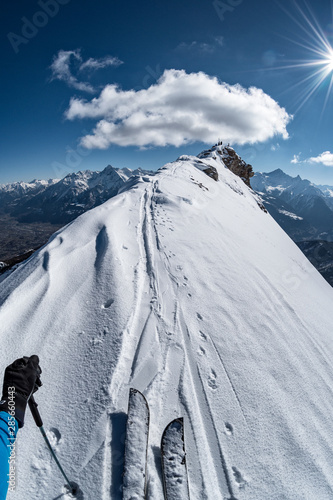 Subjective view on winter crest, splitboarder climbs to the top, alps, Aosta Valley, Italy photo