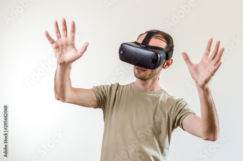 Man exploring modern technology virtual reality with head mounted display on white background