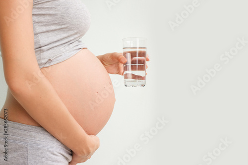 pregnant woman holds a glass of water. Food during pregnancy. Benefits of water. Pregnancy.