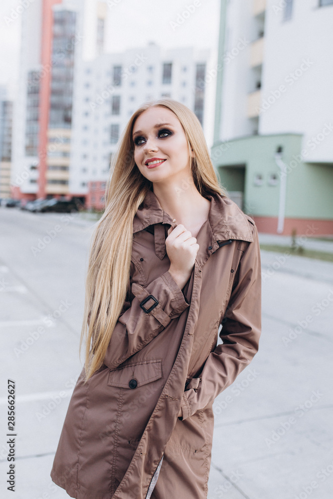 Close up street urban sexy portrait of young pretty sexual young caucasian blondie girl walking on city street in cloak and lingerie. Sexuality, beauty, fashion concept Close up street urban sexy portrait of young pretty sexual young caucasian blondie girl walking on city street in cloak and lingerie. Sexuality, beauty, fashion concept