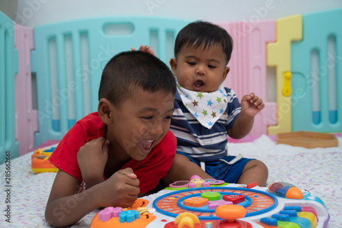 Two little brother baby play toy in room