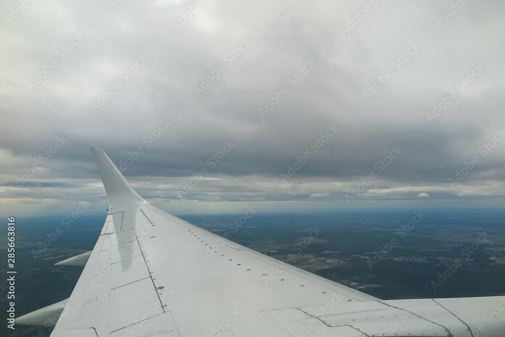 View from the plane to the clouds and city