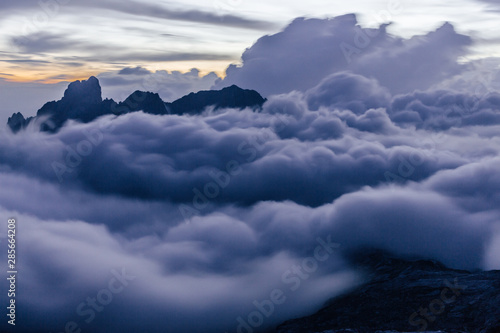 Stunning sunset over mountain alpine landscape and high summits or peak of Gosaukamm ridge, Dachstein. Sunset or sunrise colors in Alps, low clouds, motion blurr. Dreamy landscape.