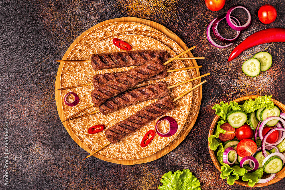 Traditional middle eastern, arabic or mediterranean meat kebab with vegetables and lavash bread. Traditional middle eastern, arabic or mediterranean meat kebab with vegetables and lavash bread.