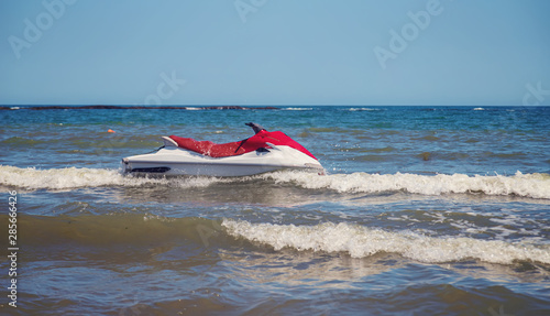 Red and white jet ski splashing on waves