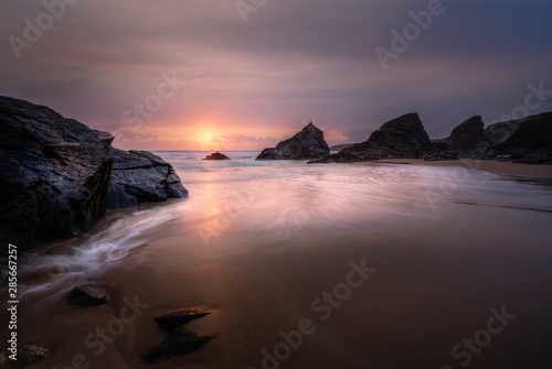 Sunset at the beautiful Bedruthan Steps in North Cornwall  with Silhouetted Sea Stacks  and Surf over Beach.