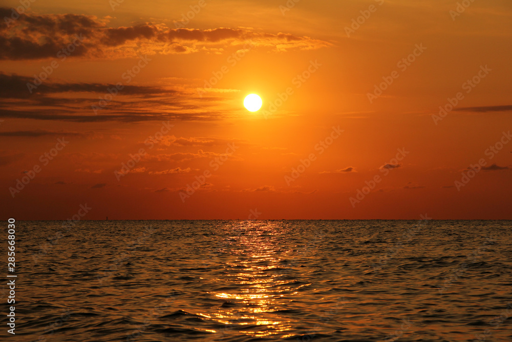Beautiful sunset at the sea. The sea in the foreground. Background
