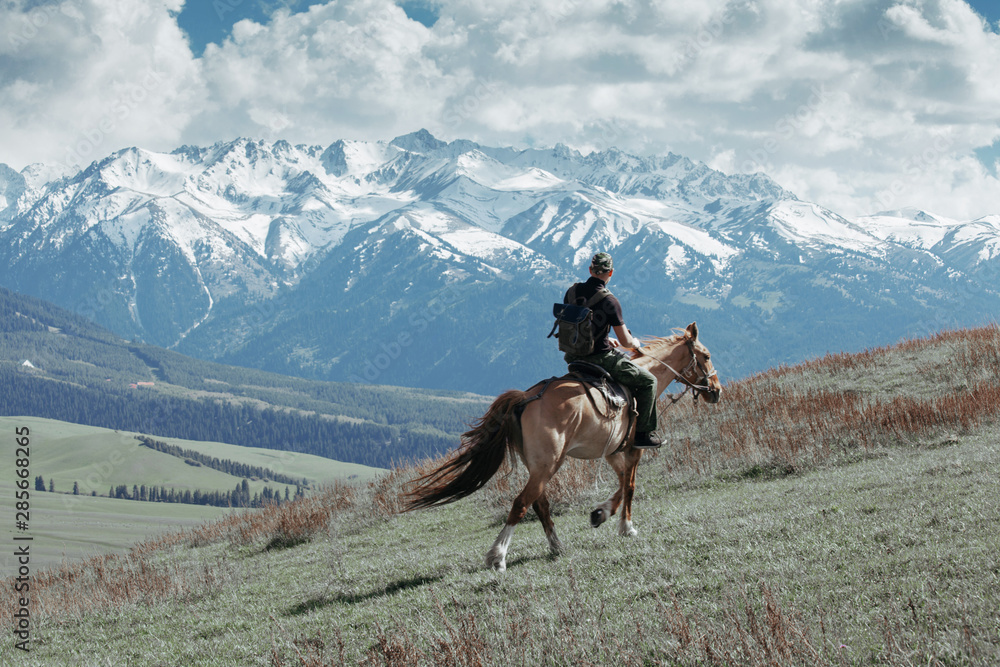 Man ridding horse on field at the mountains Man ridding horse on field at the mountains