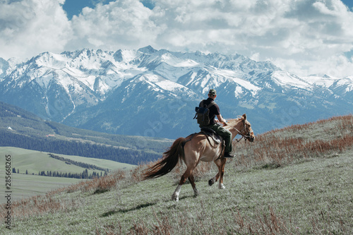 Man ridding horse on field at the mountains