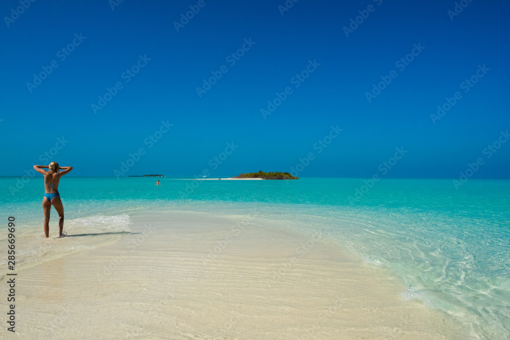 Woman looks at distant island in the Maldives