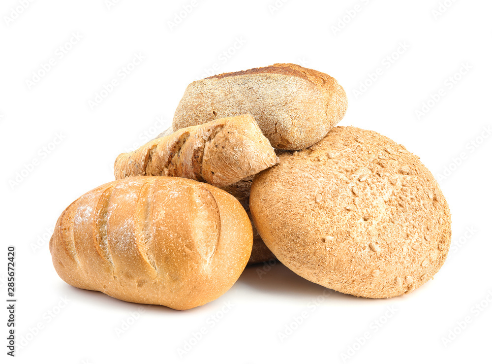 Loaves of different breads on white background