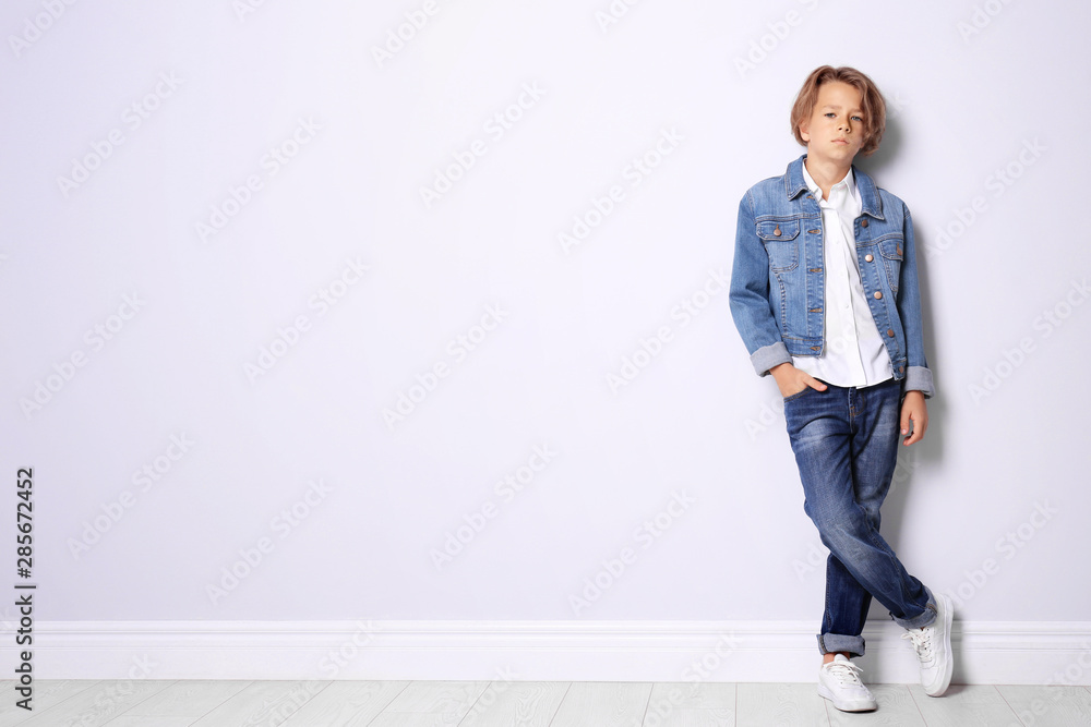 Cute little boy in casual outfit near white wall. Space for text - obrazy, fototapety, plakaty 