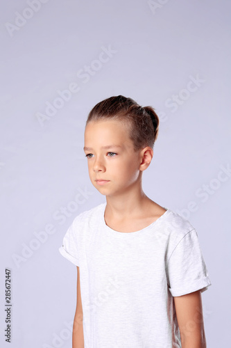 Cute little boy in casual outfit on light background