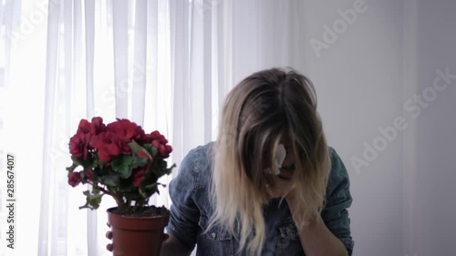 pathogen, young girl with flower in her hands suffers from an allergy to pollen constantly sneezes and wipes with handkerchief photo