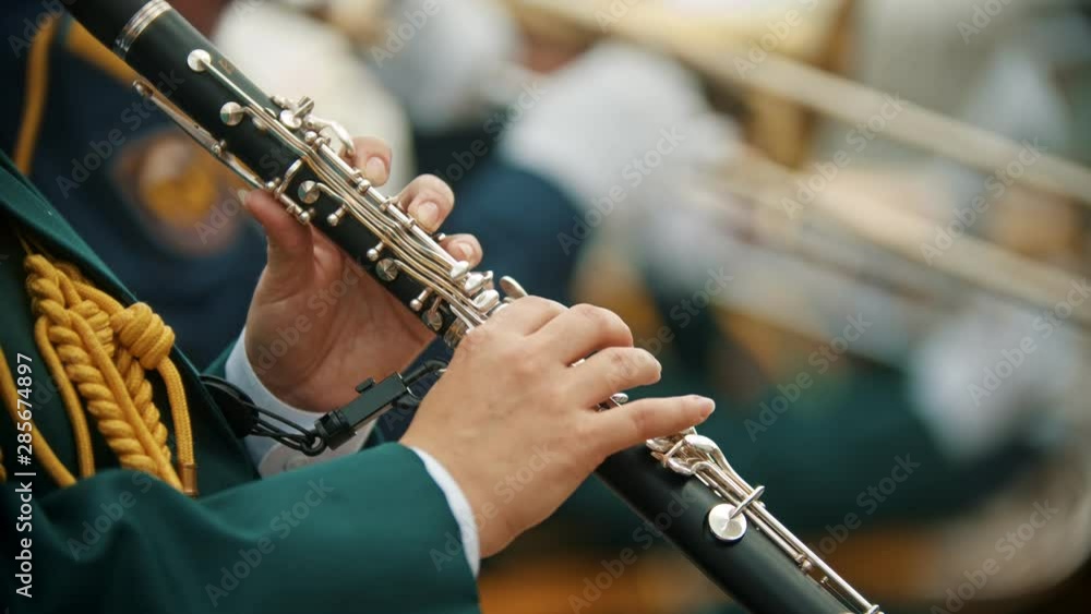 A wind instrument parade - a man in green costume playing clarinet at the military music festival