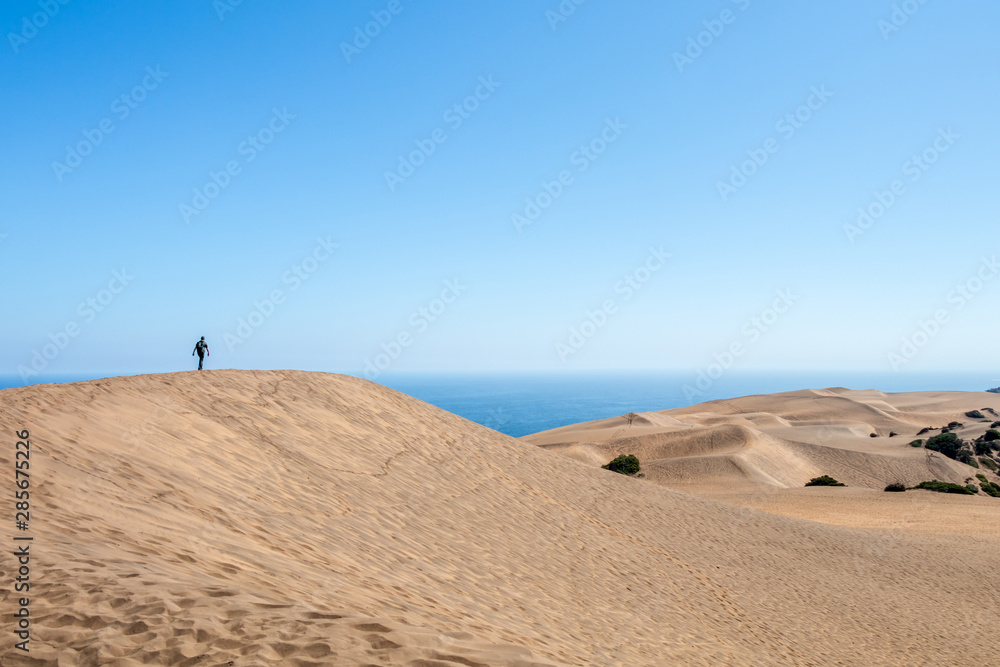 Young caucasian male traveler trekking at Concon sand dune in Vina del Mar, Chile Young caucasian male traveler trekking at Concon sand dune in Vina del Mar, Chile