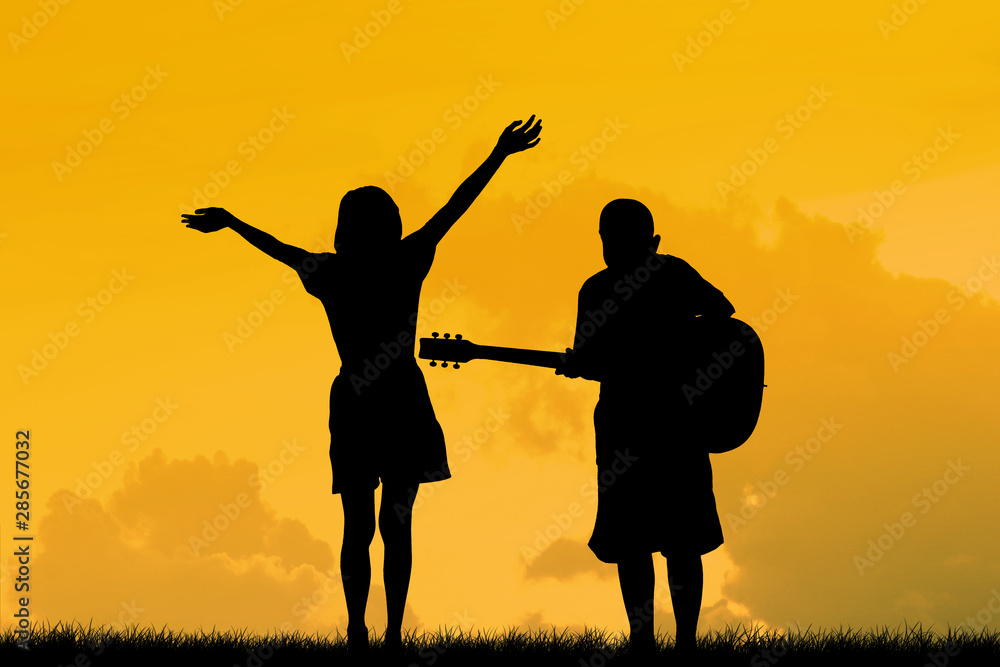silhouette a Children, jump and dance have fun , who have dreams of being a musician.Asian kid,Silhouette at the sunset, Happy time. silhouette a Children, jump and dance have fun , who have dreams of being a musician.Asian kid,Silhouette at the sunset, Happy time.