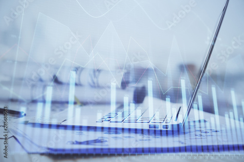 Forex graph hologram on table with computer background. Multi exposure. Concept of financial markets.