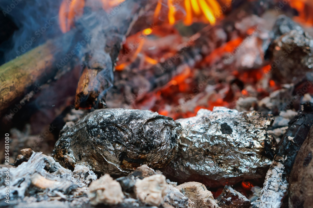 Zegetables in foil in the fire. Potatoes baked on the fire. Zegetables in foil in the fire. Potatoes baked on the fire.