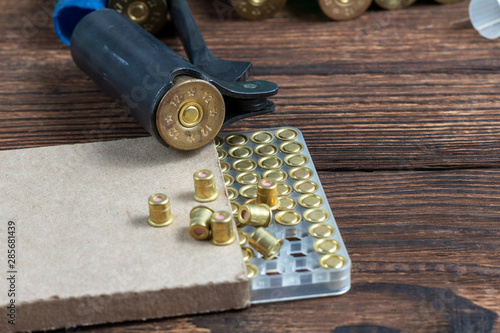 Shotgun shells reloading process with special reload equipment. Powder, bullets, fraction, shells, buckshot on the wooden background. photo