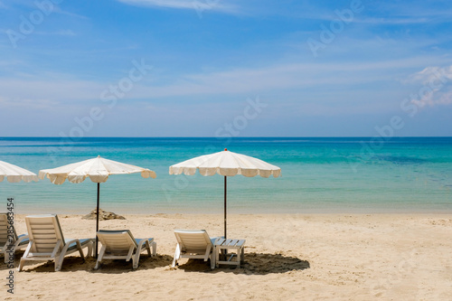 Lounge chairs with sun umbrella on a beach. Sun of summer time on sky and sand of beach relaxation landscape viewpoint. Ocean nature tranquility  Thailand.