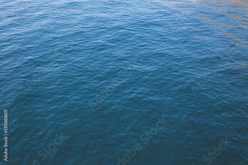 Waves on calm water in a harbor during sunset, with evening mood