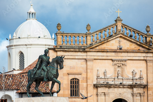 Historic equestrian monument to the Liberator Simon Bolivar with the Basilica of St. James the Apostle on background at the Bolivar Square in the Colombian city of Tunja photo