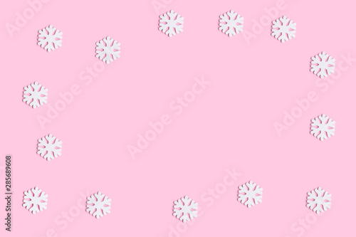 Christmas background with white snowflakes decoration on a pink background