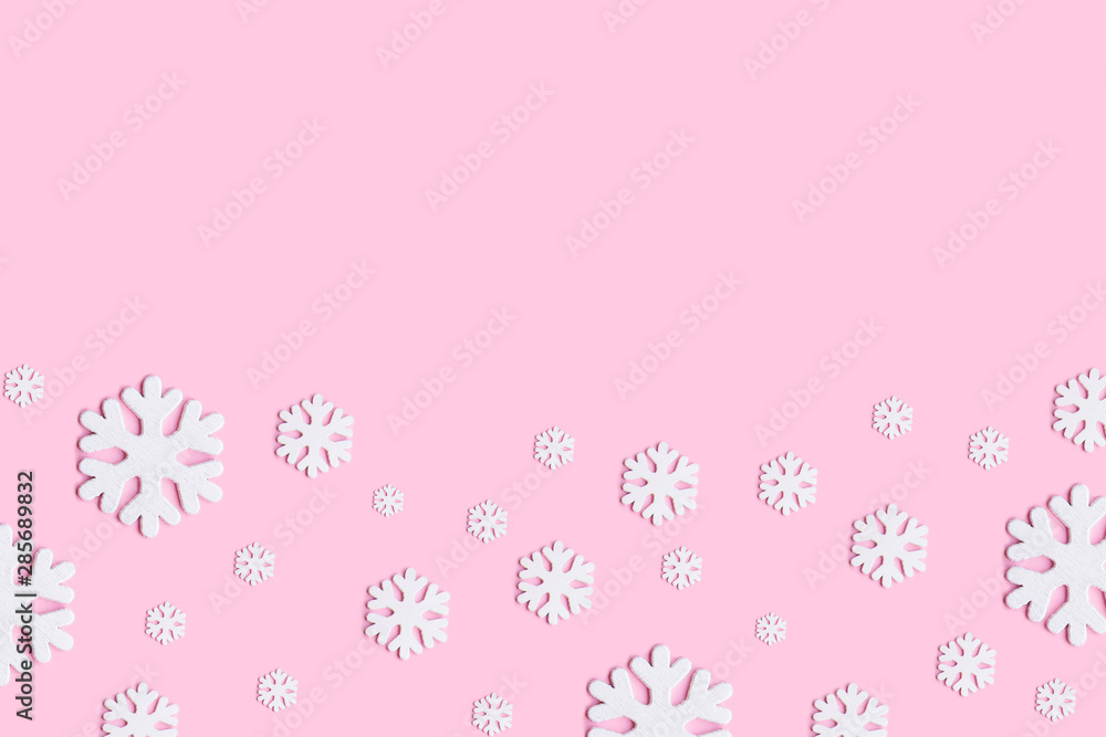 White christmas snowflakes decoration on pink background.