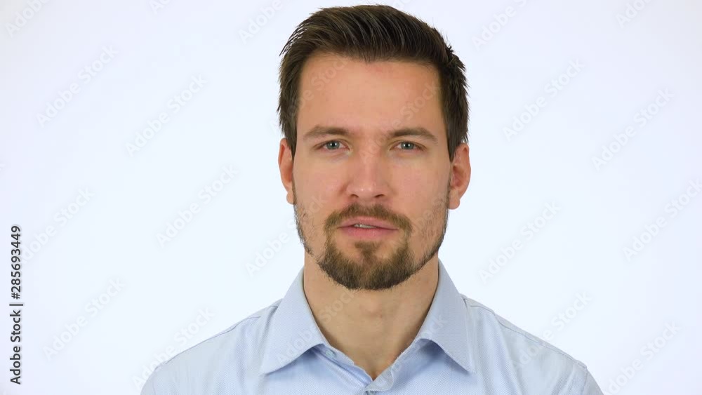 A young handsome man talks to the camera with a smile - closeup - white screen studio A young handsome man talks to the camera with a smile - closeup - white screen studio