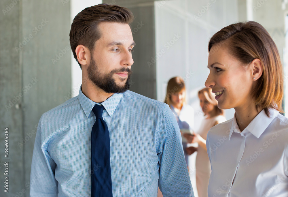 Business colleagues talking while walking in office Business colleagues talking while walking in office