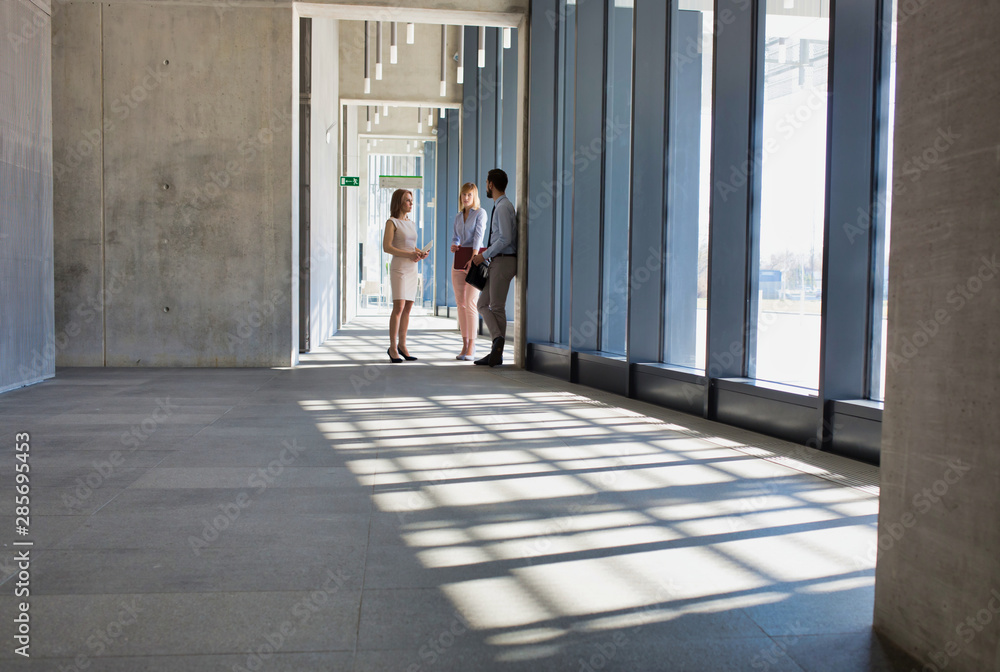 Business people talking in office corridor Business people talking in office corridor