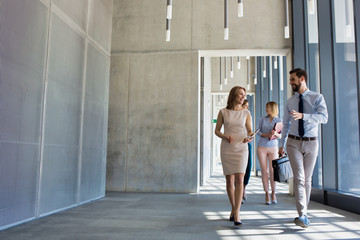 Business people walking in office corridor