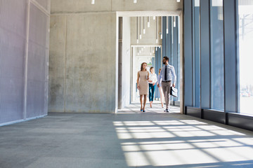 Business people walking in office corridor